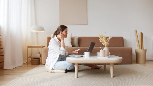 Lady sitting in the floor in front of her computer.
